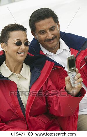 Couple photographing self with camera phone on yacht View Large Photo Image Stock Image - Couple photographing self with camera phone on yacht. Fotosearch