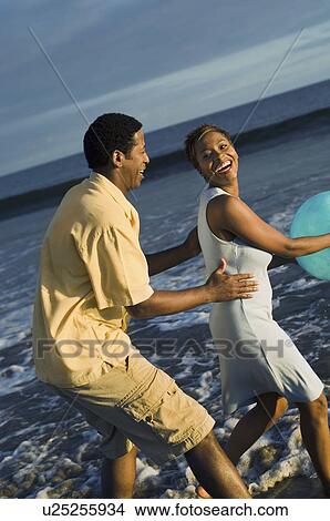 Couple playing with ball on beach View Large Photo Image Picture - Couple playing with ball on beach. Fotosearch