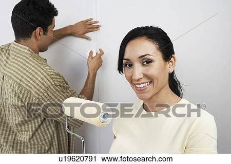 Stock Image - Couple preparing to paint room. Fotosearch