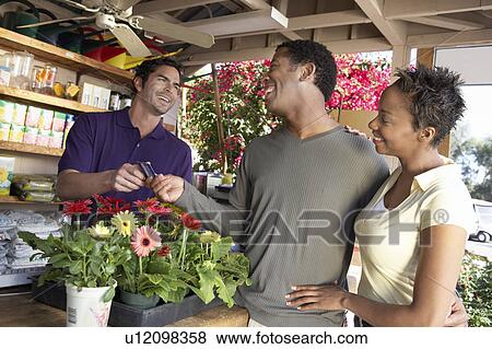 Stock Photo - Couple purchasing plants in shop. Fotosearch