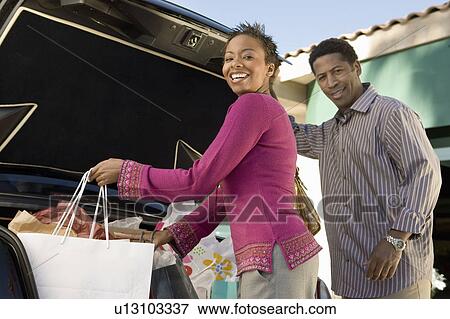 Couple putting shopping bags into boot of car, portrait View Large Photo Image Stock Photo - Couple putting shopping bags into boot of car, portrait. Fotosearch