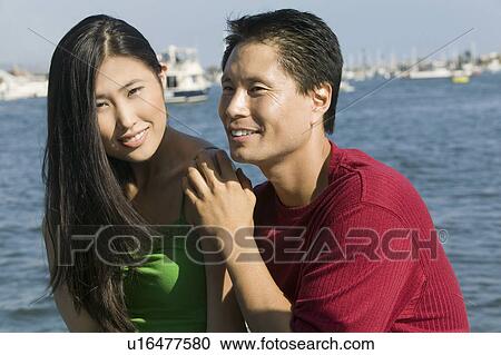 Stock Image - Couple relaxing on boat, (portrait). Fotosearch