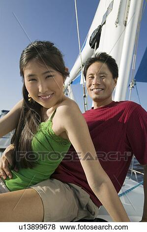 Stock Photo - Couple relaxing on boat, (portrait). Fotosearch