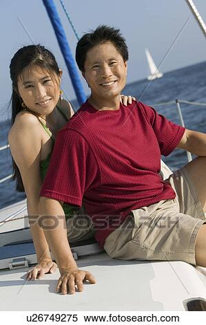 Stock Photography - Couple relaxing on boat, (portrait). Fotosearch