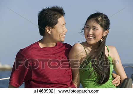 Stock Image - Couple relaxing on boat. Fotosearch