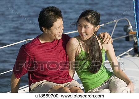Stock Image - Couple relaxing on boat. Fotosearch