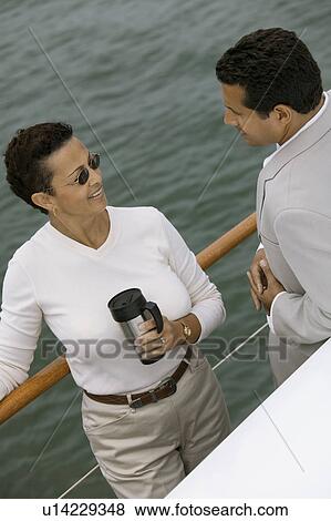 Couple relaxing on yacht, (elevated view) View Large Photo Image Stock Photo - Couple relaxing on yacht, (elevated view). Fotosearch