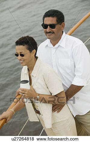 Couple relaxing on yacht, (elevated view) View Large Photo Image Stock Photo - Couple relaxing on yacht, (elevated view). Fotosearch