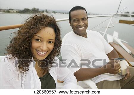 Couple relaxing on yacht, (portrait) View Large Photo Image Stock Photo - Couple relaxing on yacht, (portrait). Fotosearch