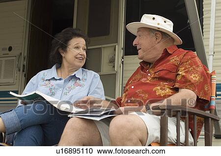 Couple relaxing outside motor home View Large Photo Image Stock Image - Couple relaxing outside motor home. Fotosearch