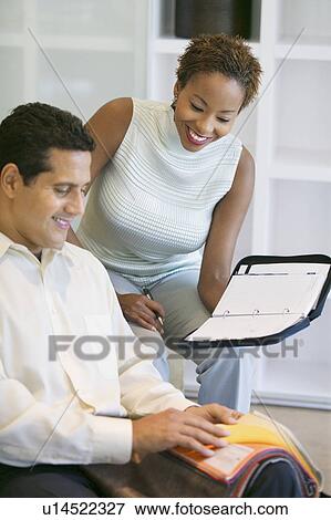 Stock Photo - Couple Selecting Fabric From Swatch. Fotosearch