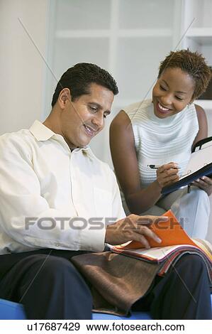 Stock Photo - Couple Selecting Fabric From Swatch. Fotosearch