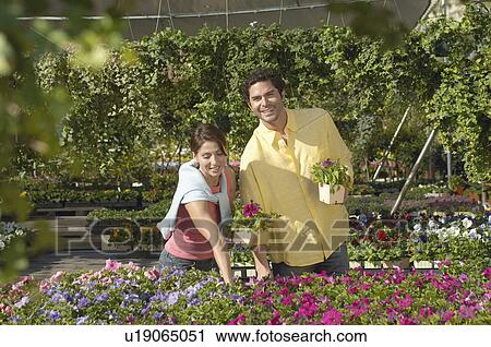 Stock Image - Couple selecting plants at nursery. Fotosearch