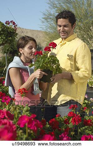 Stock Image - Couple selecting plants at nursery. Fotosearch