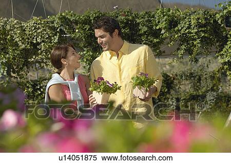 Stock Photography - Couple selecting plants at nursery. Fotosearch