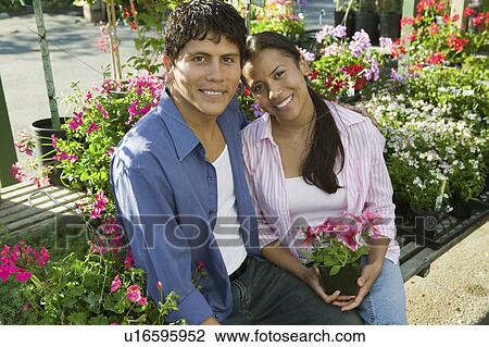 Couple Sitting Among flowers at plant nursery, portrait View Large Photo Image Stock Image - Couple Sitting Among flowers at plant nursery, portrait. Fotosearch