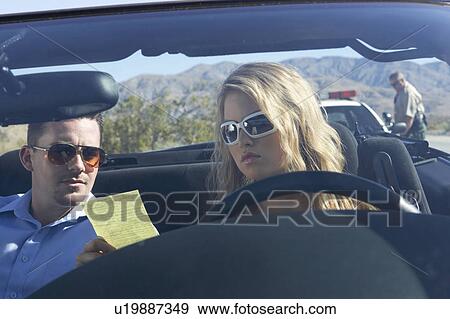 Couple sitting in car looking at traffic ticket View Large Photo Image Stock Photo - Couple sitting in car looking at traffic ticket. Fotosearch