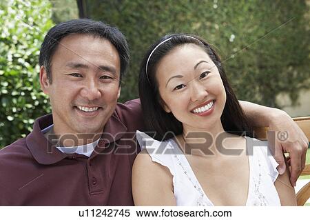 Stock Photography - Couple Sitting on Bench in Garden. Fotosearch