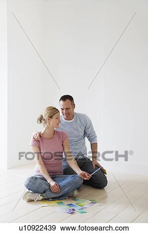 Couple sitting on floor looking at paint swatches View Large Photo Image Stock Photo - Couple sitting on floor looking at paint swatches. Fotosearch