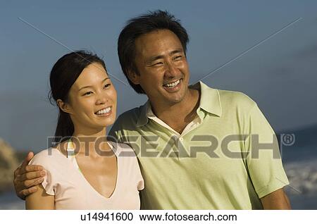 Stock Image - Couple smiling on beach. Fotosearch