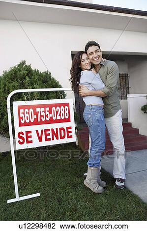 Couple standing in front of house with For Sale sign, portrait View Large Photo Image Stock Image - Couple standing in front of house with For Sale sign, portrait. Fotosearch