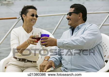 Stock Photograph - Couple toasting on yacht. Fotosearch