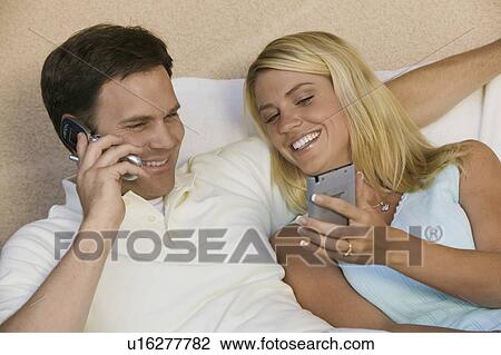 Couple Using Cell Phone and PDA View Large Photo Image Stock Image - Couple Using Cell Phone and PDA. Fotosearch