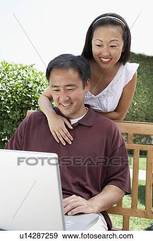 Couple Using Laptop in Garden View Large Photo Image Stock Photo - Couple Using Laptop in Garden. Fotosearch