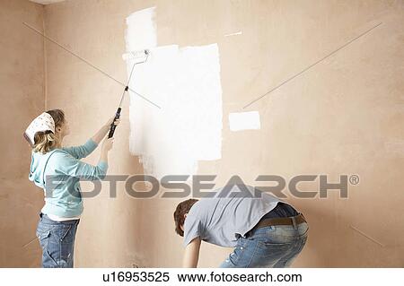 Couple using paint rollers on interior room View Large Photo Image Stock Photography - Couple using paint rollers on interior room. Fotosearch