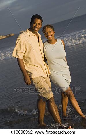 Couple walking at ocean, (portrait) View Large Photo Image Stock Image - Couple walking at ocean, (portrait). Fotosearch