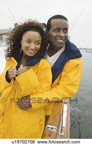 Couple wearing yellow anoraks on yacht View Large Photo Image Stock Photo - Couple wearing yellow anoraks on yacht. Fotosearch