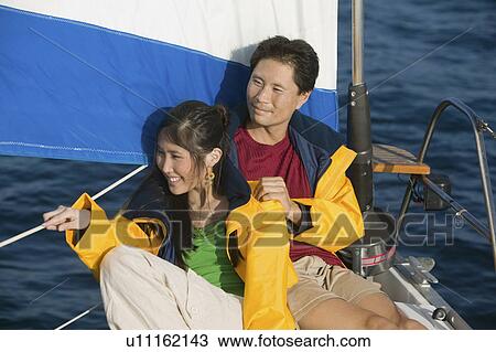 Couple wearing yellow anoraks relaxing on yacht View Large Photo Image Stock Image - Couple wearing yellow anoraks relaxing on yacht. Fotosearch