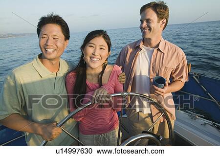 Couple with friend on yacht, (portrait) View Large Photo Image Stock Image - Couple with friend on yacht, (portrait). Fotosearch