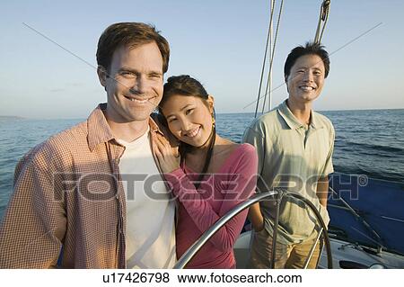 Couple with friend on yacht, (portrait) View Large Photo Image Stock Photo - Couple with friend on yacht, (portrait). Fotosearch