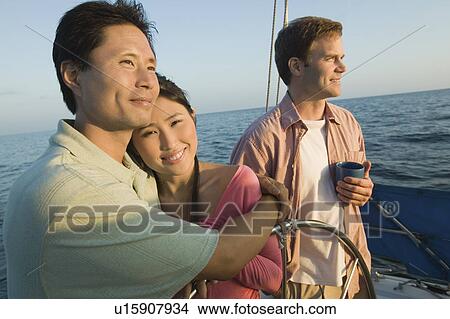 Couple with friend relaxing on yacht View Large Photo Image Picture - Couple with friend relaxing on yacht. Fotosearch