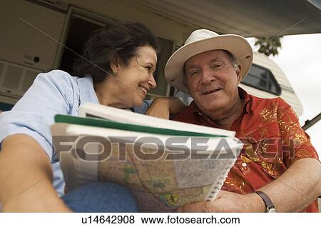 Couple with map book outside motor home View Large Photo Image Stock Photo - Couple with map book outside motor home. Fotosearch
