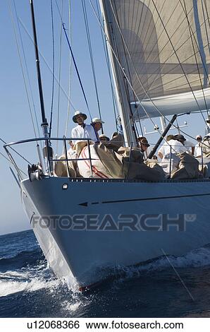 Stock Photograph - Crew on sailboat on ocean. Fotosearch