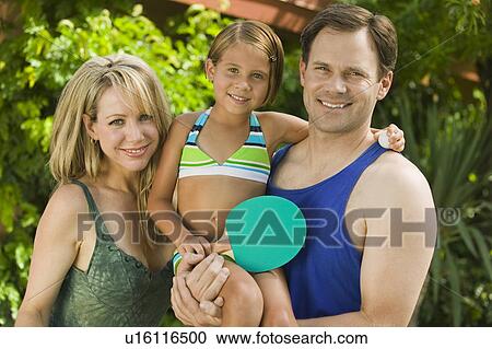 Daughter (7-9) holding ping-pong paddle, with parents, portrait. View Large Photo Image Stock Image - Daughter (7-9) holding ping-pong paddle, with parents, portrait.. Fotosearch