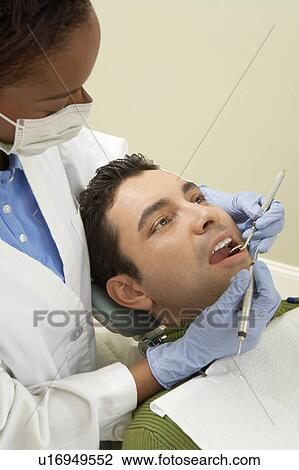Dentist examining male patient, (close-up) View Large Photo Image Stock Image - Dentist examining male patient, (close-up). Fotosearch