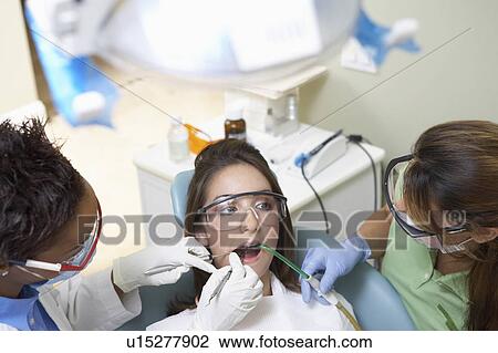 Dentists examining patients teeth in surgery, (elevated view) View Large Photo Image Stock Image - Dentists examining patients teeth in surgery, (elevated view). Fotosearch
