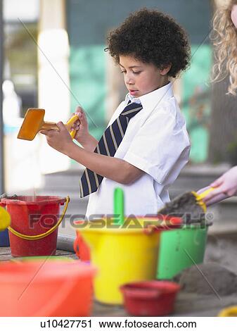 Elementary schoolboy playing in sand pit in school playground View Large Photo Image Stock Image - Elementary schoolboy playing in sand pit in school playground. Fotosearch