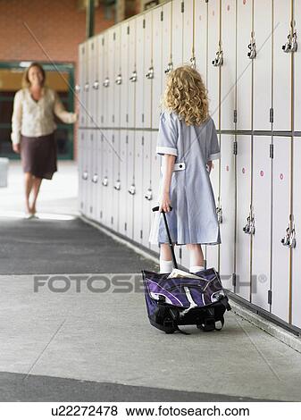 Elementary schoolgirl walking towards mother along school lockers, back view View Large Photo Image Stock Photo - Elementary schoolgirl walking towards mother along school lockers, back view. Fotosearch