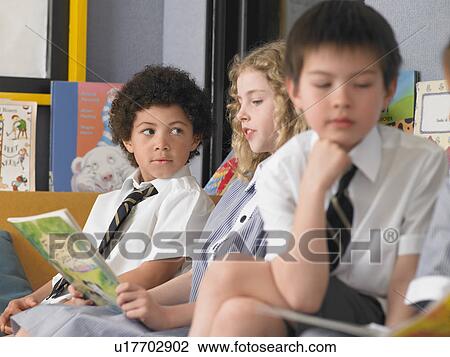 Elementary students reading books, sitting in classroom View Large Photo Image Stock Image - Elementary students reading books, sitting in classroom. Fotosearch