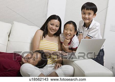 Family on Couch Using Laptop, portrait View Large Photo Image Stock Image - Family on Couch Using Laptop, portrait. Fotosearch