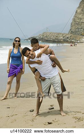 Stock Image - Family Playing on Beach. Fotosearch
