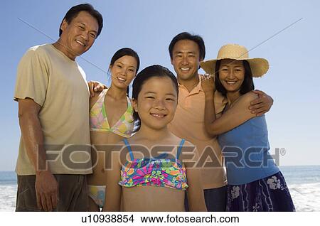 Picture - Family with girl (7-9) on beach, (portrait). Fotosearch