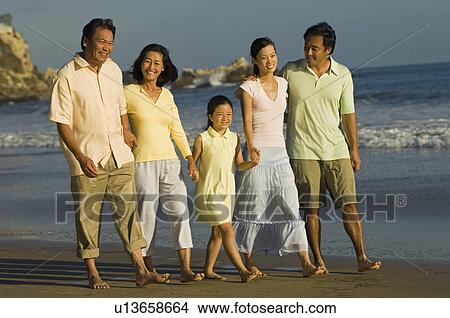 Family with girl (7-9) walking on beach View Large Photo Image Picture - Family with girl (7-9) walking on beach. Fotosearch