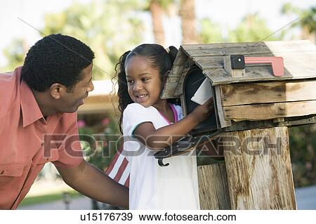 Stock Photo - Father and Daughter checking mail at domestic Mailbox. Fotosearch