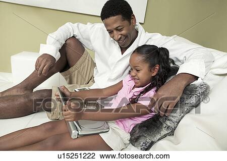 Father and Daughter on sofa Watching Movie on Portable DVD Player View Large Photo Image Stock Image - Father and Daughter on sofa Watching Movie on Portable DVD Player. Fotosearch