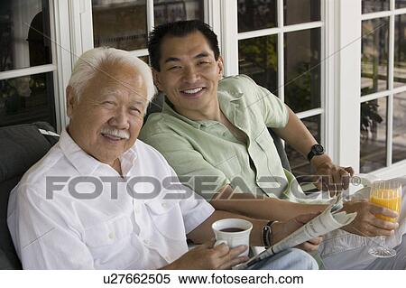 Stock Photography - Father and son sitting outside home, (portrait). Fotosearch